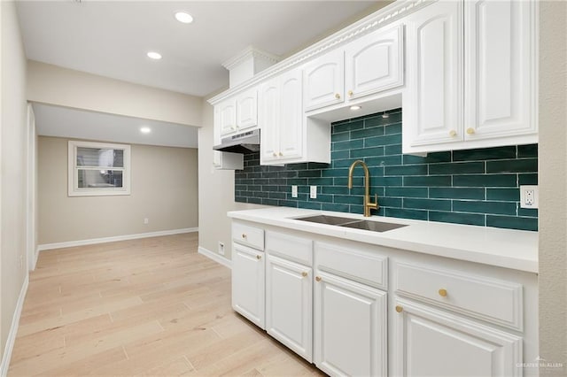 820 Beech Ave Unit 1, Mcallen, TX 78501 - kitchen with a sink, baseboards, decorative backsplash, light wood finished floors, and white cabinets