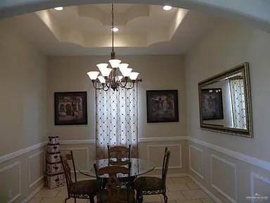 dining space featuring a tray ceiling and a notable chandelier