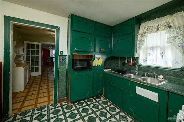 912 W Pierce Ave, Harlingen, TX 78550 - kitchen featuring green cabinets, black microwave, light floors, a sink, and dark countertops