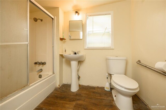 912 W Pierce Ave, Harlingen, TX 78550 - full bathroom featuring toilet, wood finished floors, and enclosed tub / shower combo