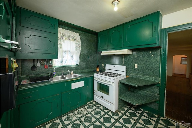912 W Pierce Ave, Harlingen, TX 78550 - kitchen featuring green cabinets, white gas range oven, a sink, under cabinet range hood, and tasteful backsplash