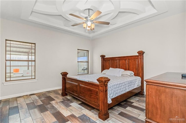 bedroom featuring hardwood / wood-style flooring, ceiling fan, a raised ceiling, and coffered ceiling