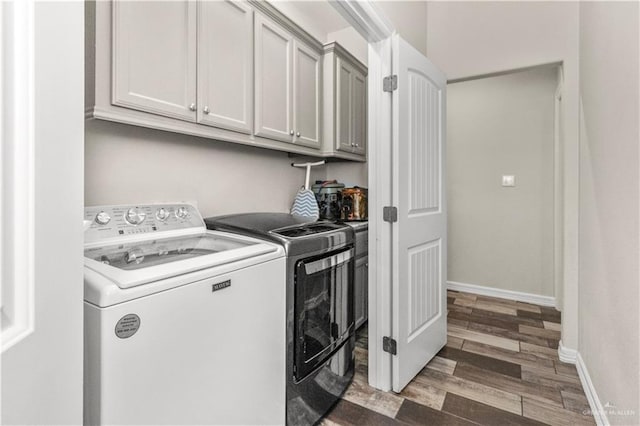 washroom with cabinets, dark wood-type flooring, and washing machine and clothes dryer