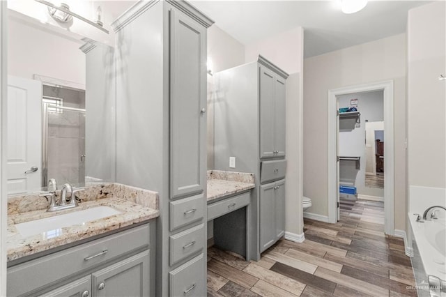 full bathroom featuring vanity, toilet, wood-type flooring, and plus walk in shower