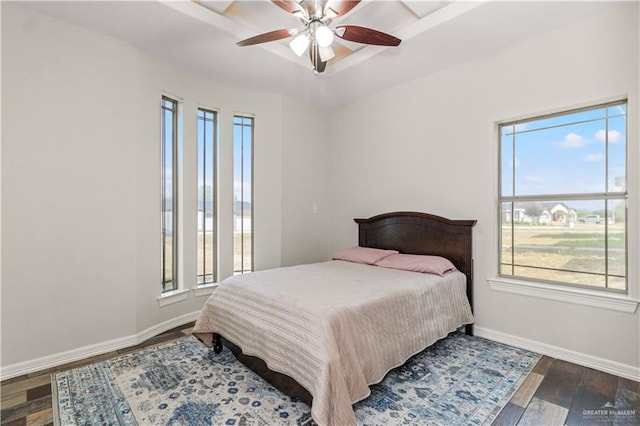 bedroom with ceiling fan, dark hardwood / wood-style flooring, and multiple windows