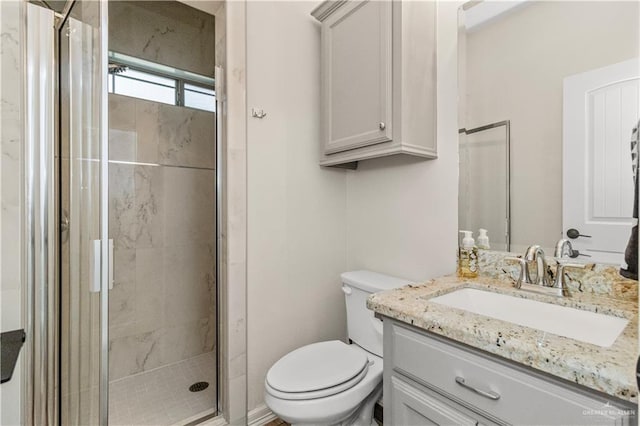 bathroom featuring vanity, toilet, and an enclosed shower