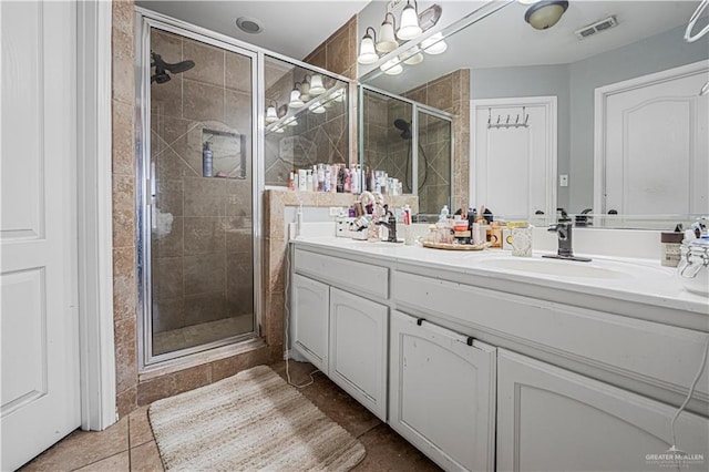 bathroom featuring vanity, an enclosed shower, and tile patterned floors