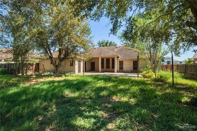 rear view of house featuring a yard and a patio