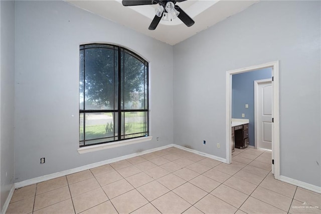 spare room with ceiling fan and light tile patterned flooring