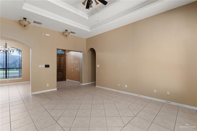 tiled spare room with ceiling fan with notable chandelier and a raised ceiling