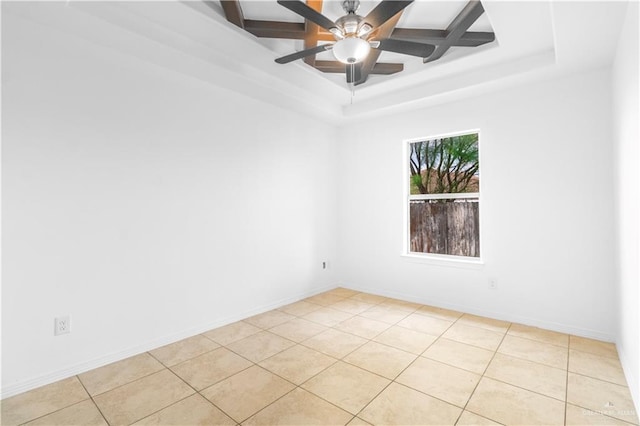 empty room with light tile patterned floors, baseboards, a ceiling fan, and a tray ceiling