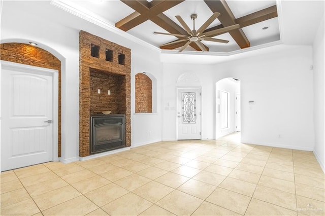 unfurnished living room with ceiling fan, a large fireplace, beam ceiling, light tile patterned floors, and coffered ceiling