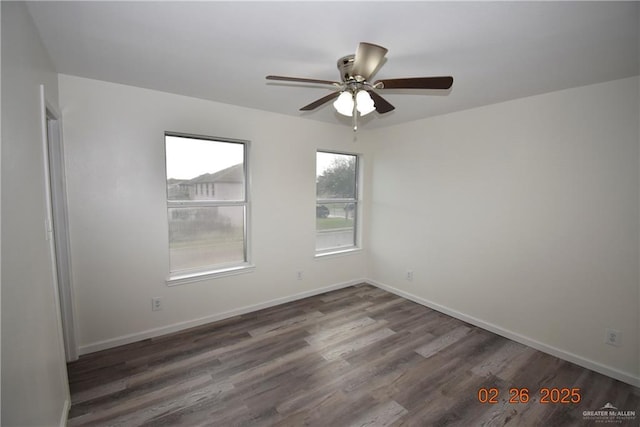 empty room featuring baseboards, wood finished floors, and a ceiling fan