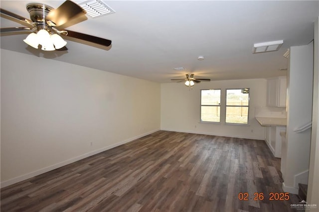 unfurnished living room featuring a ceiling fan, baseboards, and dark wood-style flooring