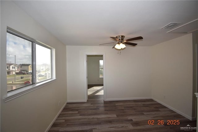 unfurnished room with ceiling fan, wood finished floors, visible vents, and baseboards