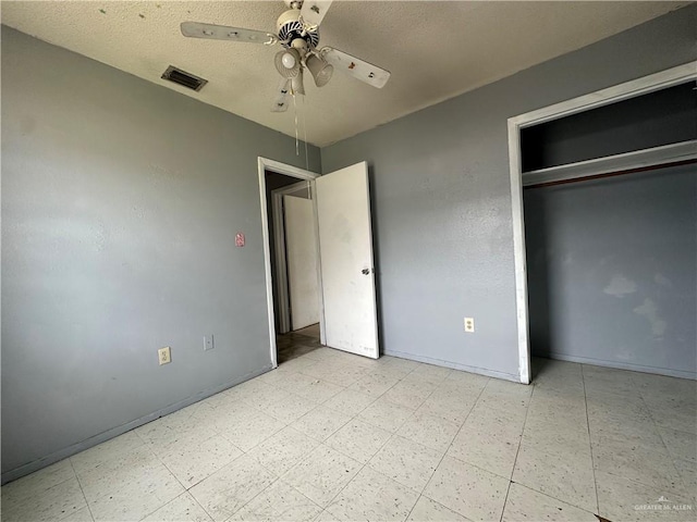 unfurnished bedroom featuring a textured ceiling, ceiling fan, and a closet