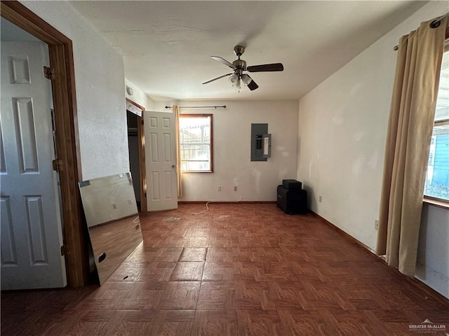 unfurnished bedroom with ceiling fan, electric panel, and dark parquet floors