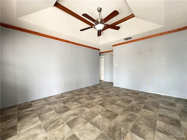 spare room with a raised ceiling, ornamental molding, and ceiling fan