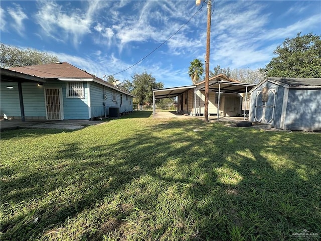 view of yard with cooling unit, a carport, and a shed