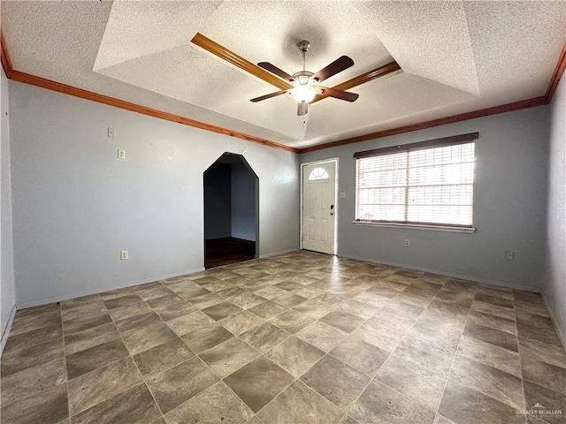 spare room featuring a raised ceiling, ornamental molding, a textured ceiling, and ceiling fan