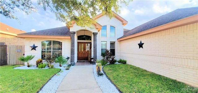 doorway to property with a lawn