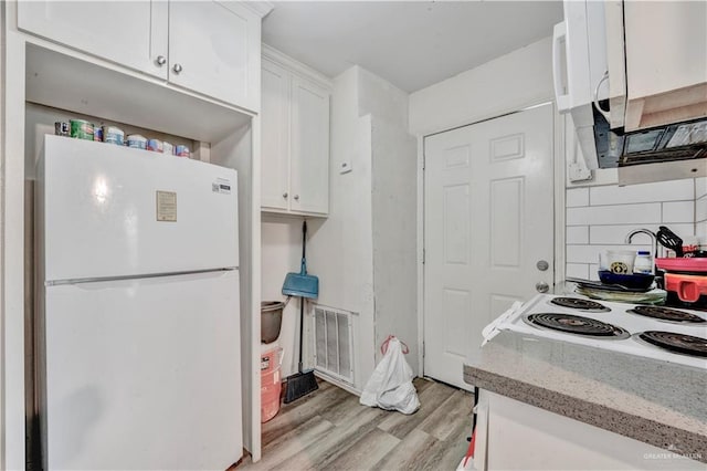 406 S 21st St, Mcallen, TX 78501 - kitchen with white appliances, white cabinets, light wood-style floors, tasteful backsplash, and light stone counters