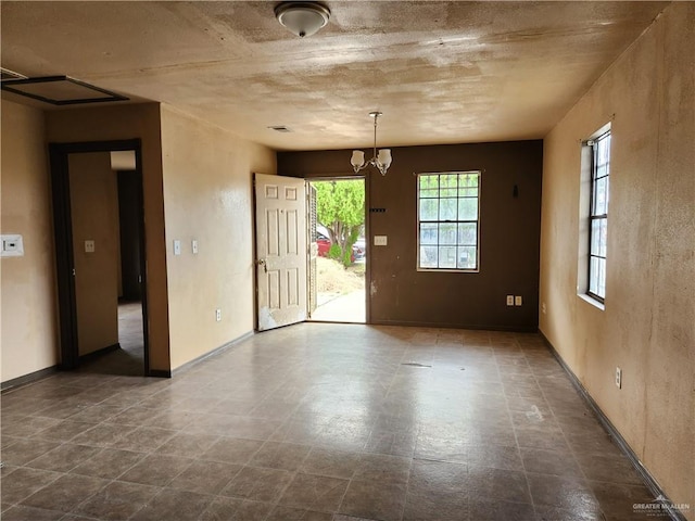 spare room with an inviting chandelier