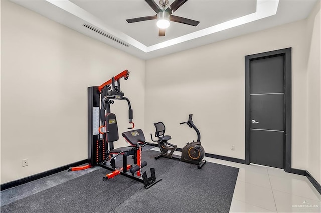 workout area featuring a raised ceiling, visible vents, ceiling fan, and baseboards