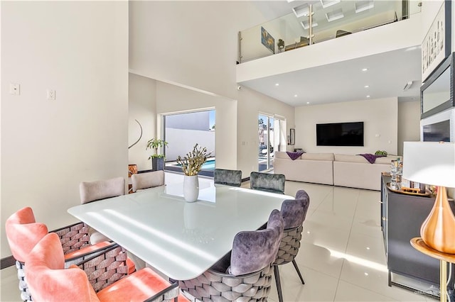 dining room featuring light tile patterned flooring and a towering ceiling