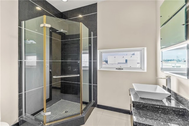 bathroom featuring baseboards, a stall shower, vanity, and tile patterned floors