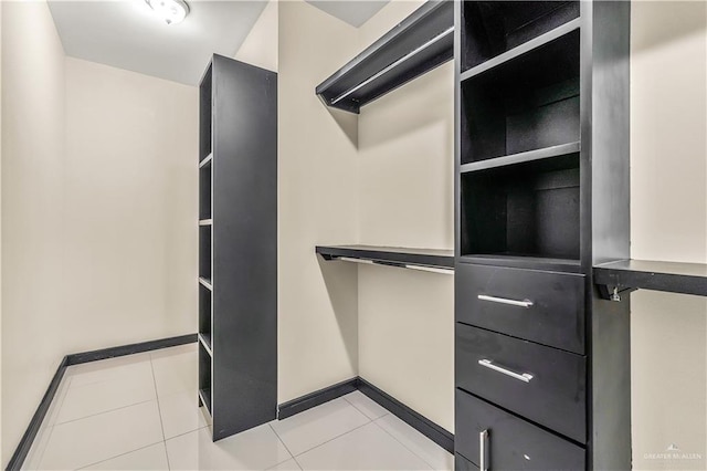 walk in closet with light tile patterned floors