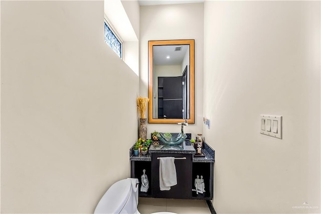 bathroom with toilet, visible vents, and vanity