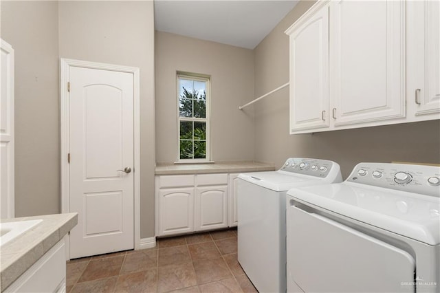 clothes washing area featuring cabinets and separate washer and dryer