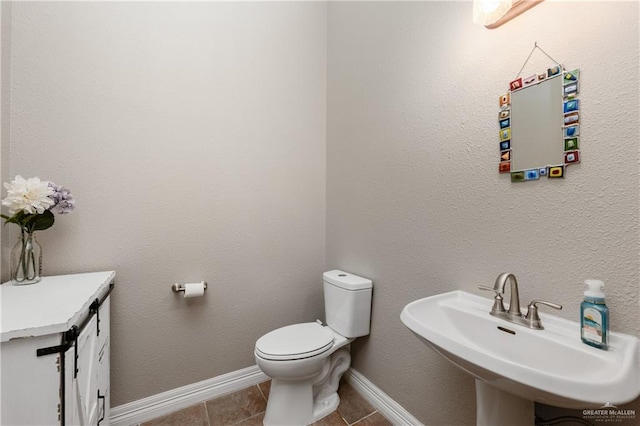 bathroom featuring tile patterned flooring, toilet, and sink