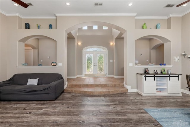 foyer entrance featuring hardwood / wood-style flooring, ornamental molding, and french doors