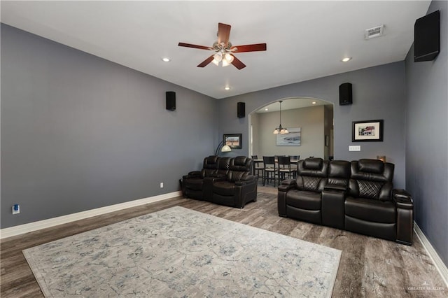 cinema with hardwood / wood-style floors and ceiling fan