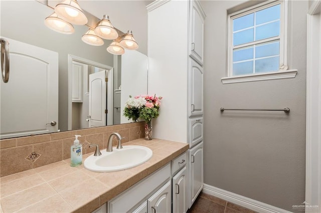 bathroom featuring tile patterned flooring, decorative backsplash, and vanity