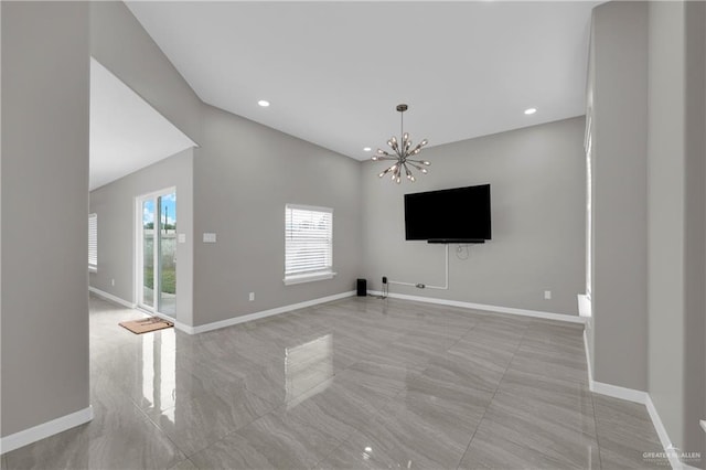 unfurnished living room featuring a wealth of natural light, a chandelier, and baseboards