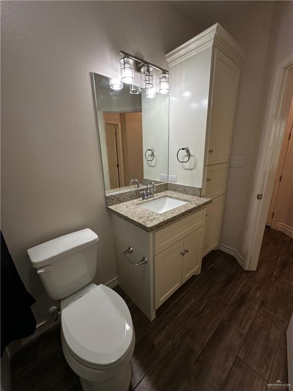 bathroom featuring vanity, wood-type flooring, and toilet