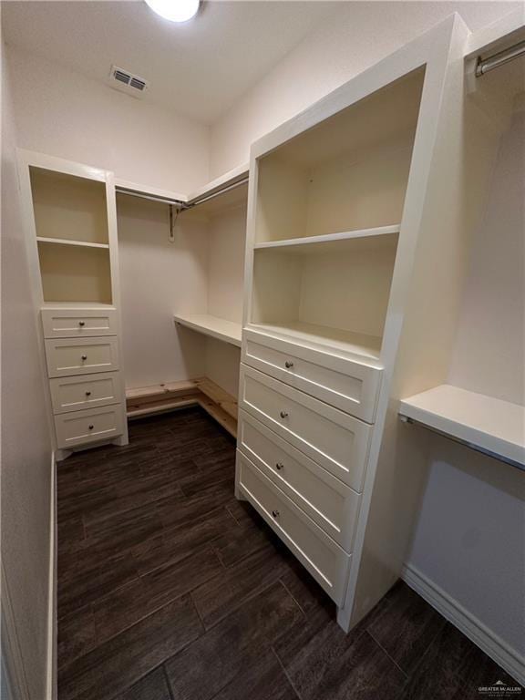 spacious closet with dark hardwood / wood-style flooring