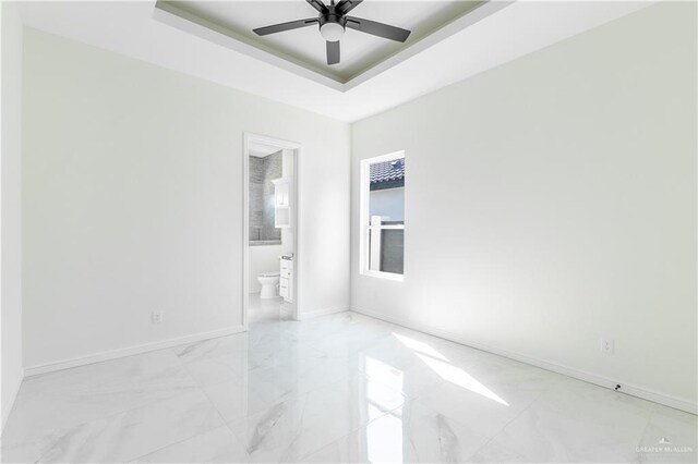 unfurnished room with a raised ceiling and ceiling fan