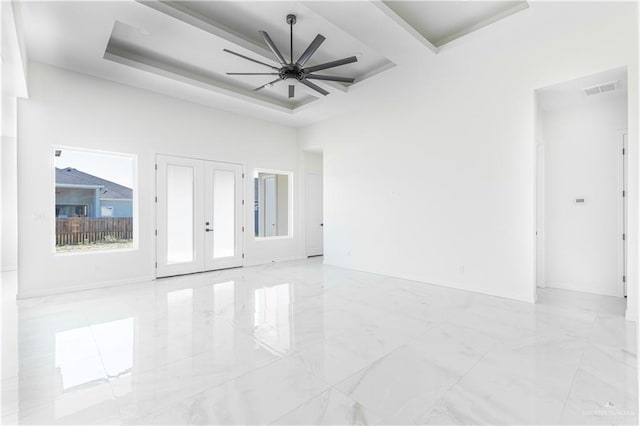 spare room with ceiling fan, a tray ceiling, and french doors