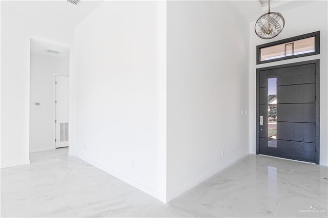 entryway featuring a towering ceiling and a notable chandelier