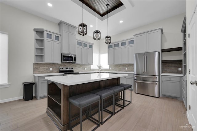 kitchen with stainless steel appliances, a kitchen island, glass insert cabinets, and open shelves