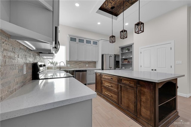 kitchen featuring glass insert cabinets, decorative light fixtures, a center island, stainless steel appliances, and open shelves