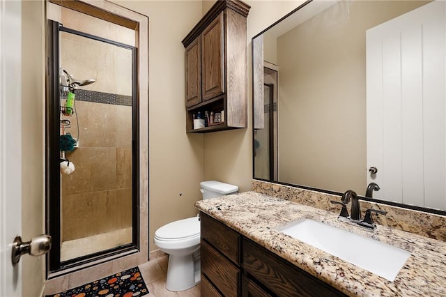 bathroom featuring tile patterned flooring, vanity, an enclosed shower, and toilet