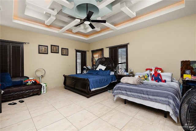 tiled bedroom with a tray ceiling, ceiling fan, and coffered ceiling