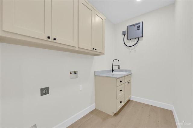 laundry area featuring sink, cabinets, light hardwood / wood-style floors, hookup for a washing machine, and electric dryer hookup