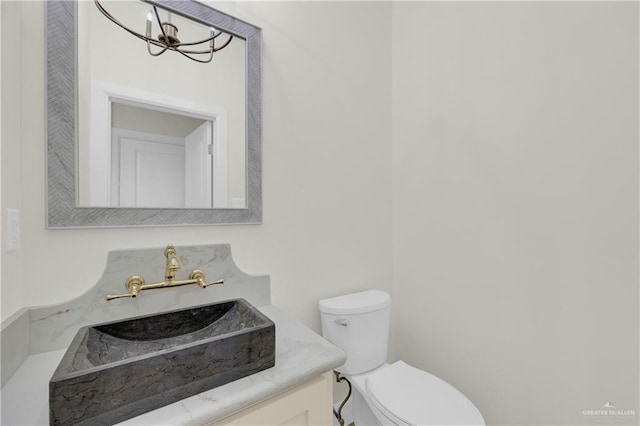 bathroom with vanity, a chandelier, and toilet