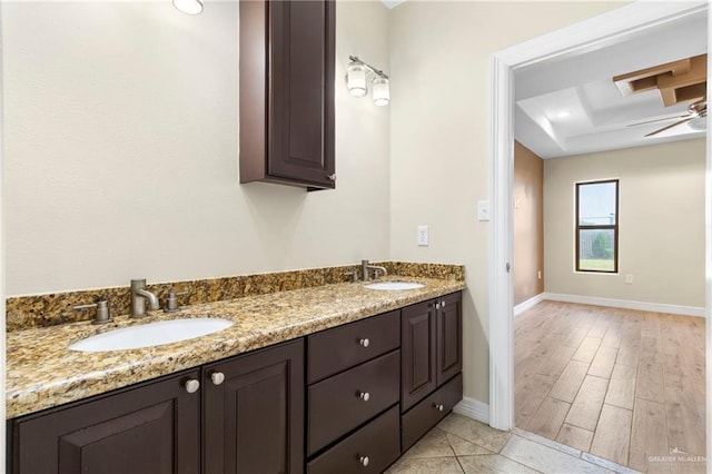 2601 Moreno Sr, Edinburg, TX 78541 - bathroom with baseboards, a raised ceiling, wood finished floors, and double vanity